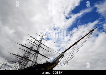 Il tea clipper il Cutty Sark a Greenwich fotografati da un basso angolo di cielo blu e nuvole dietro. Foto Stock