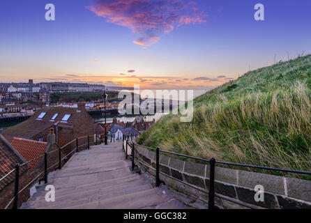 Tramonto sul mare del Nord, la città vecchia e il porto di Whitby visto dal 199 passi Foto Stock