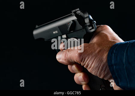 PM pistola makarov in man mano su sfondo nero Foto Stock