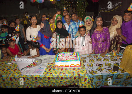 Famiglia bengalese e amici festeggiare il compleanno del loro 3 anno vecchio ragazzo di notte nel loro cortile a Brooklyn, New York. Foto Stock