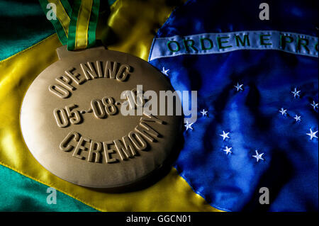 RIO DE JANEIRO - Febbraio 3, 2016: grande medaglia d'oro per commemorare la cerimonia di apertura del 2016 Giochi Olimpici sulla bandiera Brasile. Foto Stock