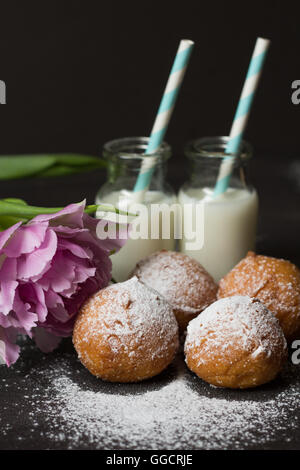 Ciambelle con marmellata e due bottiglie di latte Foto Stock