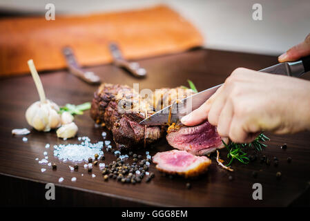 Servire il carving arrosto di maiale rotolo di carne pasto in stile rustico con condimenti Foto Stock