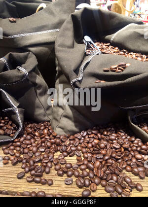 I chicchi di caffè sui sacchi su legno rustico sfondo Foto Stock