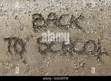 Si torna a scuola grande scritta sulla spiaggia Foto Stock