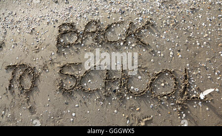 Grande scritta sulla spiaggia torna a scuola Foto Stock