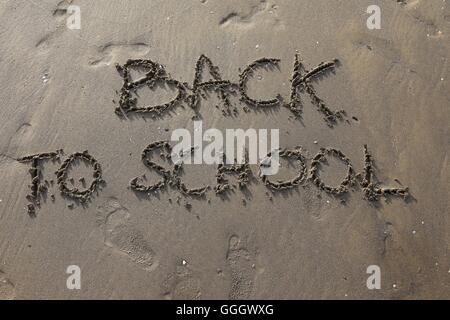 Grande scritta sulla spiaggia torna a scuola Foto Stock