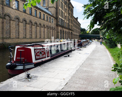 Narrowboats ormeggiate dai Salts Mill sul Leeds e Liverpool Canal in Saltaire West Yorkshire Inghilterra Foto Stock