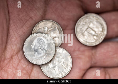 Quarti in una mano Foto Stock