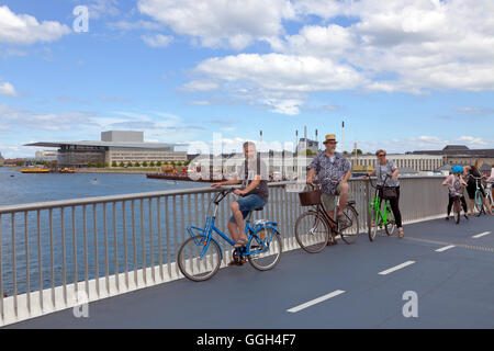 Escursioni in bicicletta i visitatori sul nuovo pedoni e ciclisti ponte il Porto Interno ponte di collegamento Nyhavn e Christianshavn. Copenhagen, Danimarca. Foto Stock