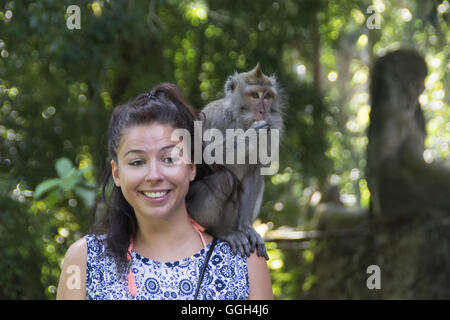 Il crab-eating macaque su una spalla di una ragazza, Indonesia. Crab-eating macachi tipicamente non consumano granchi; piuttosto, essi ar Foto Stock