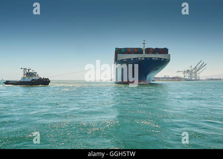 Il gigante di CMA CGM centauro di portacontainer è manovrato verso il molo J nella lunga spiaggia di terminal per container, California, Stati Uniti d'America. Foto Stock