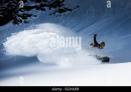 Giovani femmine snowboarder cavalcando attraverso la neve profonda in montagna, Pitztal, Tirolo, Austria Foto Stock