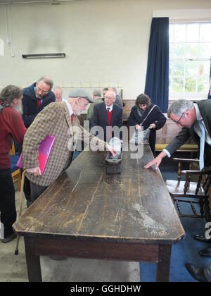 Atendees del Wirksworth Grande Corte Barmote ispezionare il minerale di piombo in ottone liberando piatto datata 1512 Foto Stock