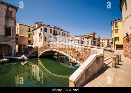 Tipico ponte attraverso un canale di Chioggia, Laguna Veneziana, Italia. Foto Stock