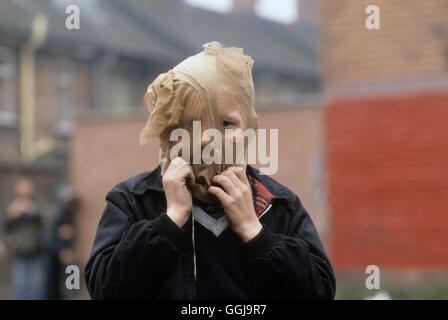 Il giovane tiratore tira una copertura sopra la testa e il viso in modo che non possa essere identificato. The Troubles Belfast Irlanda del Nord anni 1980 Regno Unito 1981 HOMER SYKES. Foto Stock