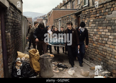 Irlanda i problemi. Belfast, anni 1980 I giovani cattolici adolescenti raccolgono materiale per costruire una bomba a benzina. Le bottiglie di latte sono riempite di benzina e viene acceso un mucchio di materiale e la bomba viene lanciata ai soldati dell'esercito britannico. 1981 UK HOMER SYKES Foto Stock