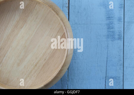 Ciotola di legno di utensili da cucina in legno blu sullo sfondo. Foto Stock