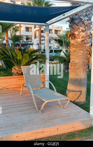 Lettini nel padiglione per il relax sul mare Mediterraneo palm beach al tramonto in Paphos, Cipro. Foto Stock