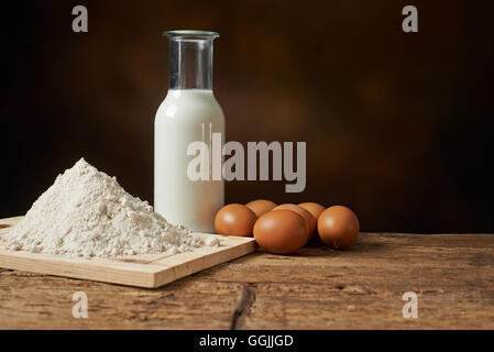 Materiali di fabbricazione, farina uova e latte su un banco di cucina Foto Stock