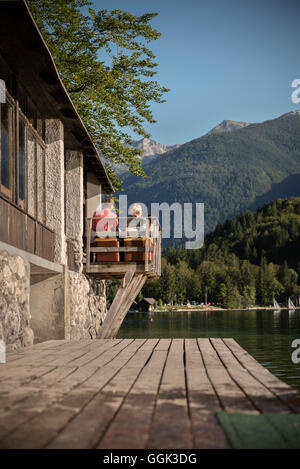 L uomo e la donna godendo della vista sul lago di Bohinj e Alpi circostanti, Bohinj intorno a Bled, Slovenia, Europa Foto Stock