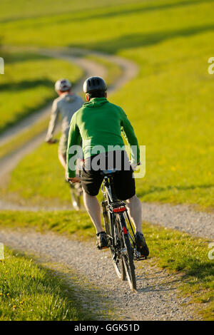 Due ciclisti in sella e-bikes, Munsing, Alta Baviera, Germania Foto Stock