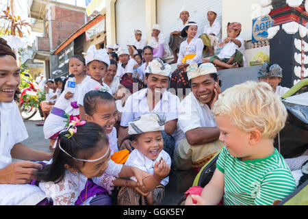 Balinese di bambini che giocano con il ragazzo straniero, ragazzi, rendendo il divertimento, rendendo volti, tempio cerimonia abito tradizionale, vestiti, boy 3 y Foto Stock