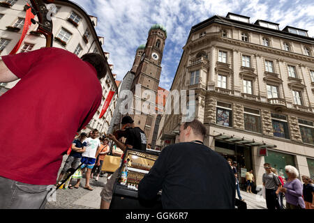 Musicisti sul Kaufingerstrasse, Frauenkirche in background, Monaco di Baviera, Germania Foto Stock