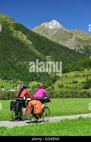 Due ciclista passando Inn percorso ciclabile verso il Piz Linard, Lavin, Bassa Engadina Cantone dei Grigioni, Svizzera Foto Stock