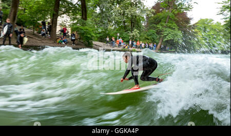 Surfer surf sul Eisbach nel Giardino Inglese, Monaco di Baviera, Baviera, Baviera, Germania Foto Stock