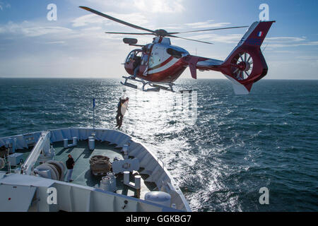 Elicottero airlifting Dunkerque pilota dalla prua della nave da crociera MS Deutschland (Reederei Peter Deilmann), mare del Nord, nei pressi di Fran Foto Stock