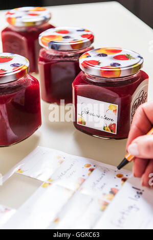 Persona la marcatura di vasi di marmellata, Amburgo, Germania Foto Stock