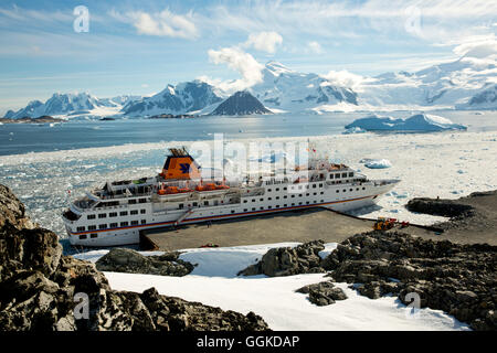 Expedition nave da crociera MS Hanseatic (Hapag-Lloyd crociere) ormeggiata presso il molo di cemento con gli iceberg e le montagne in distanc Foto Stock