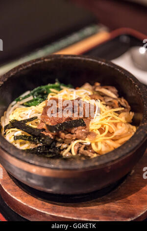 Bibimbap in una pietra riscaldata ciotola, piatto coreano Foto Stock