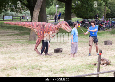 Hertfordshire, Inghilterra, circa del luglio 2016, Andy giorno, attore e wildlife presenter ad un live show di dinosauri interagente con un sconosciuto Foto Stock