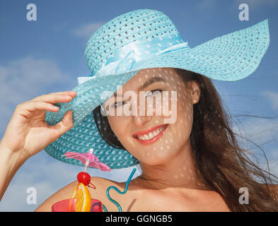 La donna caucasica bevendo un cocktail presso la spiaggia Foto Stock