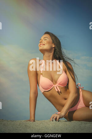 La donna caucasica in rosa bikini in spiaggia Foto Stock