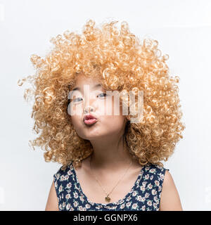 Indossa una parrucca bionda e divertente l'espressione del viso ragazza asiatica Foto Stock