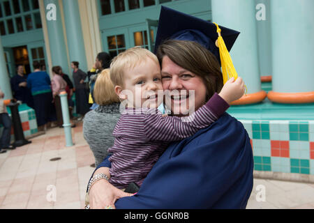 Laureato di Western governatori università pone con figlio dopo la cerimonia di inizio a Orlando in Florida. Foto Stock