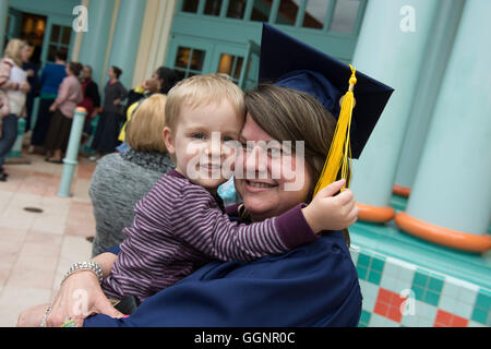 Laureato di Western governatori università pone con figlio dopo la cerimonia di inizio a Orlando in Florida. Foto Stock