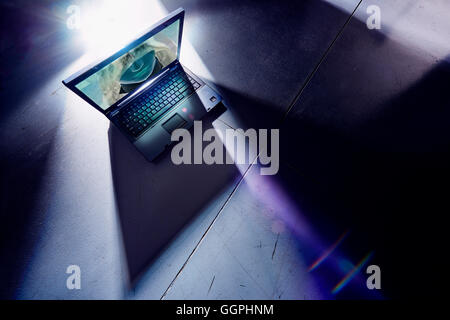 Faccia di hacker incandescente sullo schermo del computer portatile Foto Stock