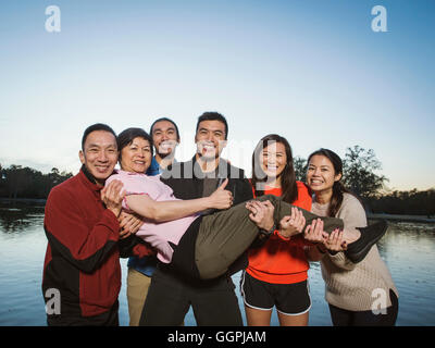 Famiglia cinese in posa vicino al lago all'aperto Foto Stock