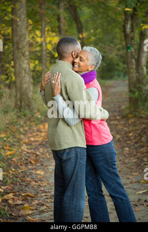 Coppia di anziani abbracciando nella foresta Foto Stock
