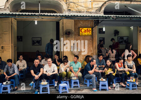 Hanoi, Vietnam - Marzo 18, 2015 - Giovani bere il caffè nel lato a piedi Foto Stock