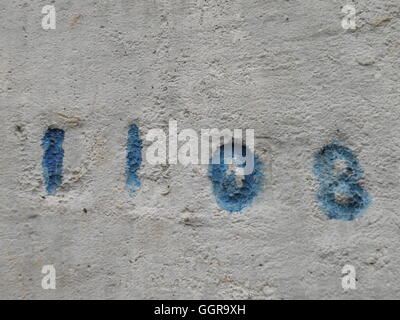 Blu casuale numeri stampigliati in una tavolozza di calcestruzzo. Foto Stock