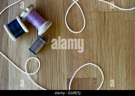 Multicolor fili di cucitura su sfondo di legno Foto Stock