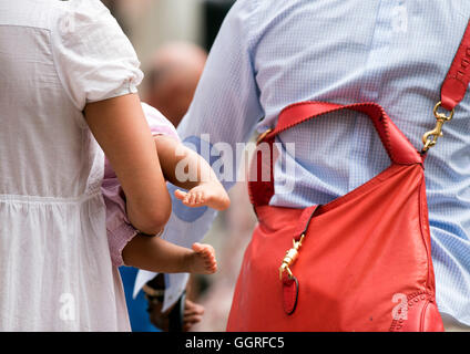 Donna bambino portando i piedi in giro per la città Foto Stock