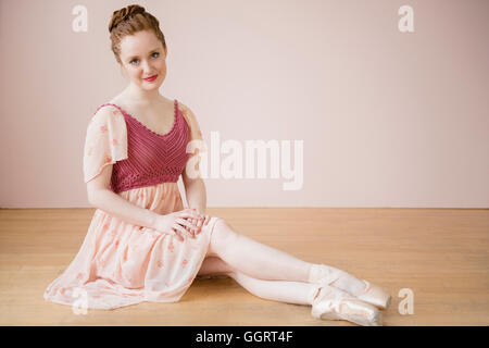 Caucasian ballerina seduta sul pavimento Foto Stock