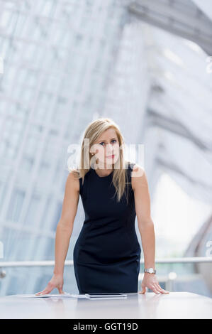 Imprenditrice caucasica appoggiata sul tavolo della sala conferenze Foto Stock