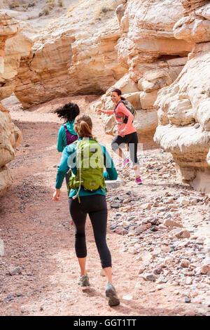 Le donne in esecuzione nel canyon indossando zaini Foto Stock